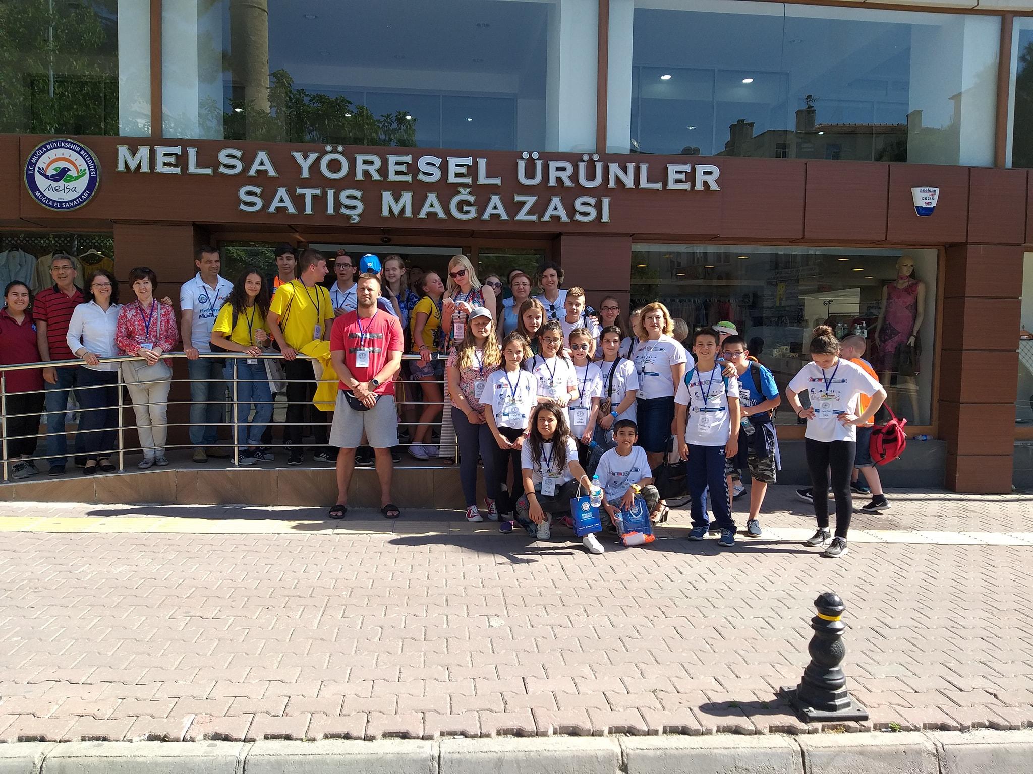 Skolotāji un skolēni stāv pie skolas Turcijā