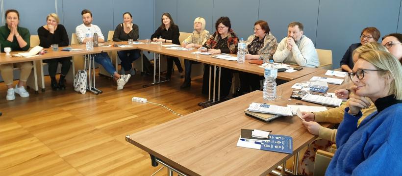 Skolotāji Erasmus+ pieredzes apmaiņā sēž pie galda un klausās