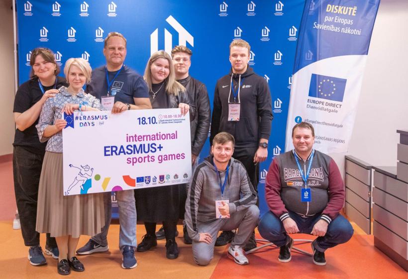 Cilvēku grupa ar plakātu rokās "Erasmus+ sporta spēles"