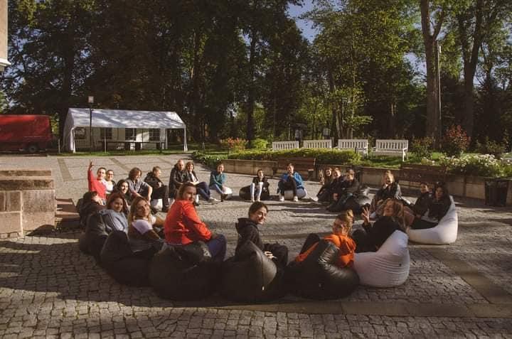 Attēlā redzami jaunieši sasēdušies aplī Erasmus+ projekta aktivitātes ietvaros