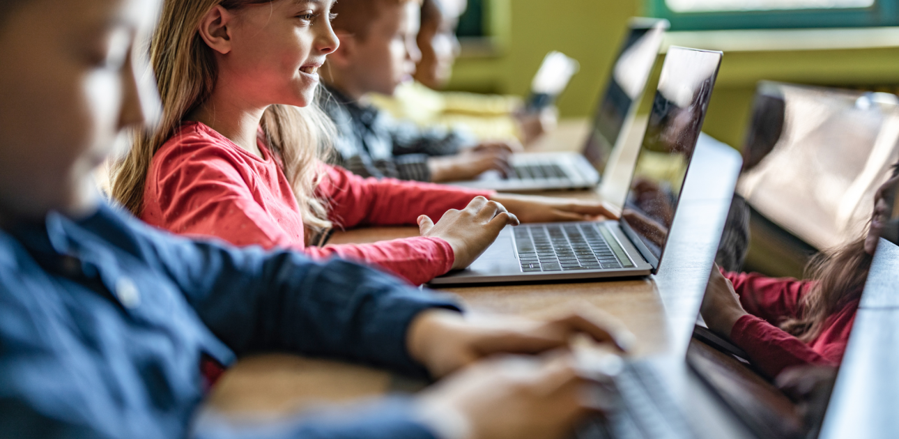 bērni mācās pie datoriem