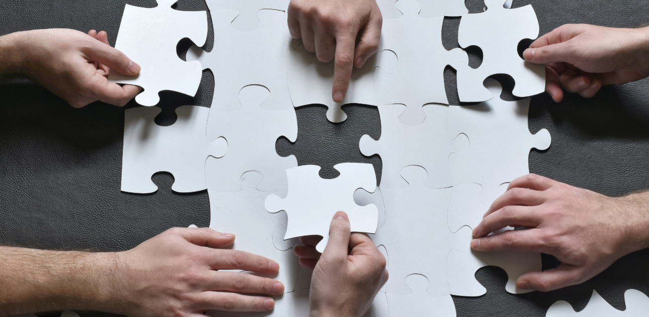 Balti puzles gabaliņi tiek likti kopā, komandas darbs