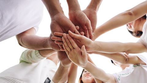 vairāki cilvēki sadevuši kopā rokas