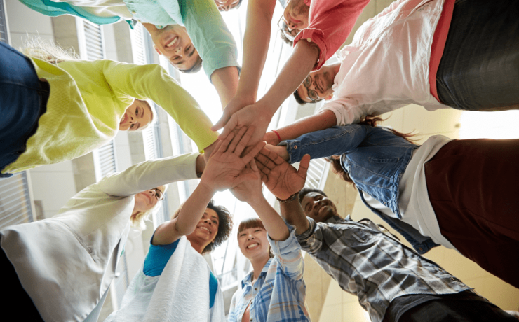 Attēlā redzami skolēnu pašpārvaldes jaunieši, kas salikuši rokas kopā kā komanda